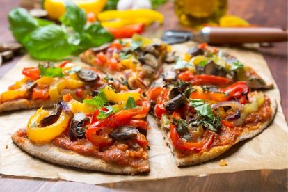 Greek inspired vegan pizza with olives, peppers and tomato with quick cashew cheese